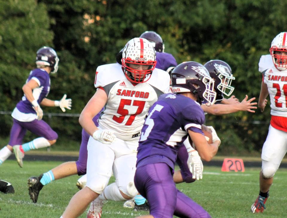 Marshwood's Ryan Essex (5) tries to elude the tackle attempt by Sanford's Canton Hill during Friday night's game in South Berwick, Maine.
