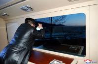 Photo diffusée le 12 janvier 2022 par l'agence nord-coréenne KCNA du leader nord-coréen Kim Jong Un regardant avec des jumelles le lancement d'un missile hypersonique, depuis un lieu non précisé en Corée du Nord (AFP/STR)