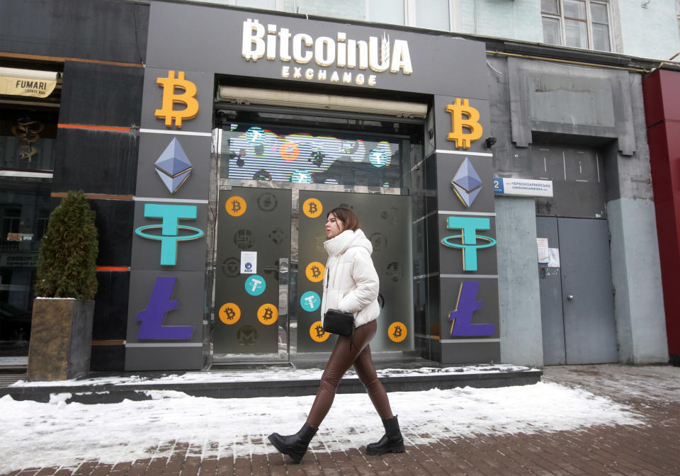 A wpman walks past a cryptocurrency exchange point in the center of Kyiv, Ukraine on 24 January 2022. Bitcoin dropped below $34 000, to six-month low, as fears of war in Ukraine shake stock markets, according to media. (Photo by STR/NurPhoto via Getty Images)