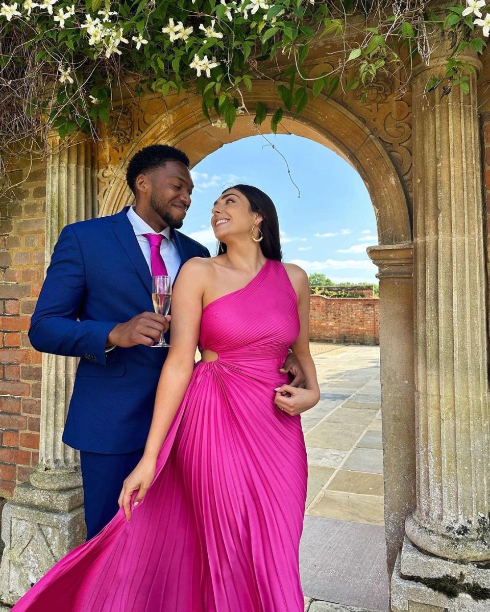 Nelly London and her boyfriend B smile at each other at a wedding