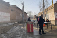 Men gather near a barricade on a road in Yinhuangying village in northern China's Hebei Province, Wednesday, Jan. 29, 2020. With barricades and wary guardians, villages on the outskirts of Beijing are closing themselves off to outsiders to ward against infection amid the outbreak of a new type of virus. (AP Photo)