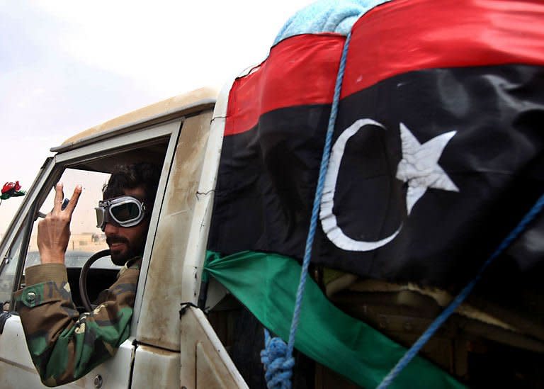 A Libyan rebel flashes the V-sign as he leaves the eastern town of Ajdabiya. Libyan regime forces pounded rebels with heavy artillery west of Ajdabiya on Sunday, forcing hundreds of residents and some fighters to flee the key crossroads town, as a refugee rescue operation in Misrata was under way