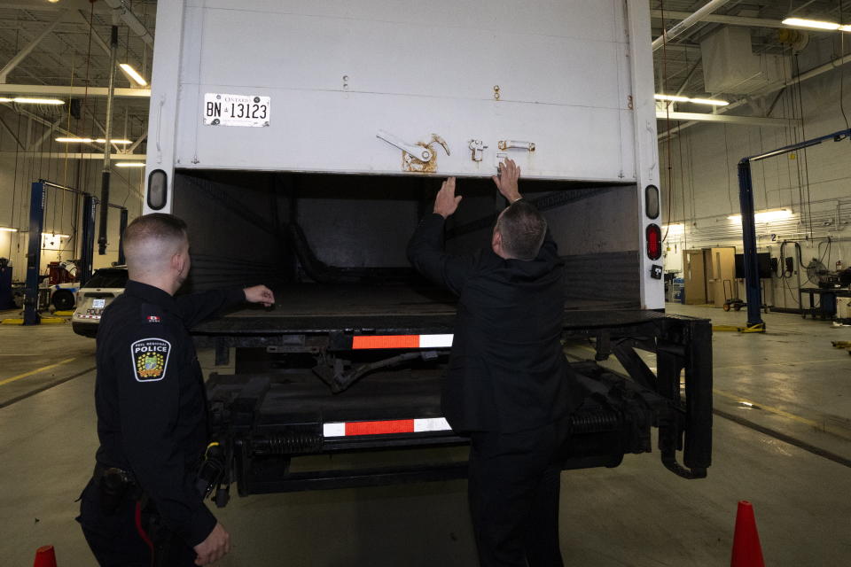 Police officers open the back of a recovered truck during a press conference regarding Project 24K a joint investigation into the theft of gold from Pearson International Airport, in Brampton, Ontario, on Wednesday, April 17, 2024. (Arlyn McAdorey/The Canadian Press via AP)