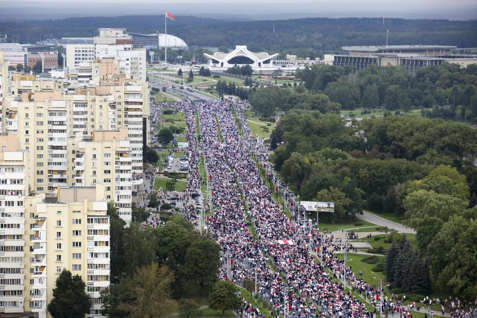 Belarusian opposition supporters with old Belarusian national flags gather toward the Independence Palace, the residential of Belarusian President Alexander Lukashenko in Minsk, Belarus, Sunday, Sept. 6, 2020. Sunday's demonstration marked the beginning of the fifth week of daily protests calling for Belarusian President Alexander Lukashenko's resignation in the wake of allegedly manipulated elections. (AP Photo/TUT.by)