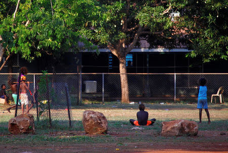 Members of the Australian Aboriginal community of Ramingining can be seen near their homes in East Arnhem Land, located east of the Northern Territory city of Darwin, Australia November 24, 2014. Picture taken November 24, 2014. REUTERS/David Gray