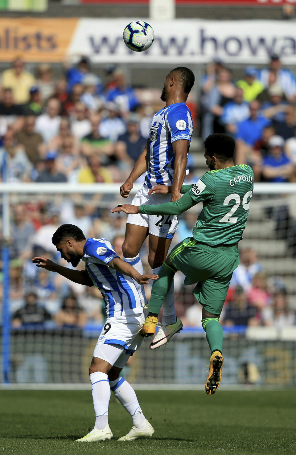 Huddersfiled Town's Steve Mounie and Watford's Etienne Capoue contest a header during the English Premier League soccer match between Huddersfield and Watford at the John Smith’s stadium, Huddersfield, England. Saturday, April 20, 2019. (Clint Hughes/PA via AP)