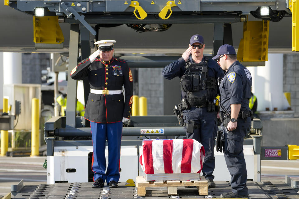 Marine First Sgt. Timothy La Sage, left, and Port Authority police officers salute as the remains of retired Marine Capt. Grady Kurpasi are transferred from a Turkish airlines plane at New York's John F. Kennedy International Airport, Friday, May 19, 2023, in New York. The remains of a U.S. Marine veteran who had been missing in Ukraine for more than a year will be returned to his family in eastern North Carolina later Friday, according to the group bringing the remains back to the U.S. (AP Photo/Mary Altaffer)