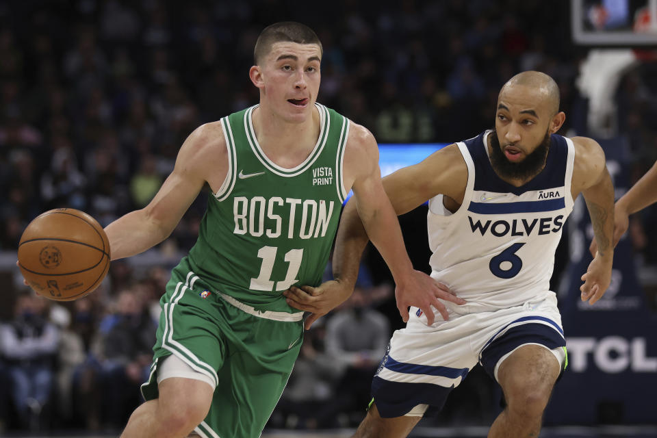 Boston Celtics guard Payton Pritchard (11) drives against Minnesota Timberwolves guard Jordan McLaughlin (6) during the first half of an NBA basketball game Monday, Dec. 27, 2021, in Minneapolis. (AP Photo/Stacy Bengs)