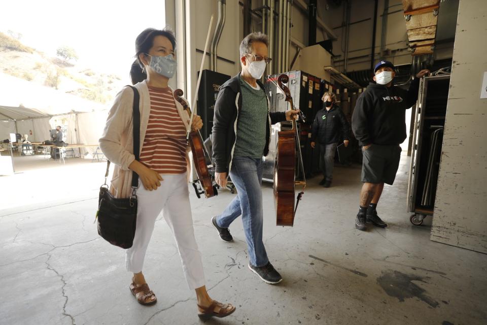 L.A. Phil's Ingrid Chun, second violin, and Barry Gold, cello, walk onstage for rehearsal at the Hollywood Bowl.