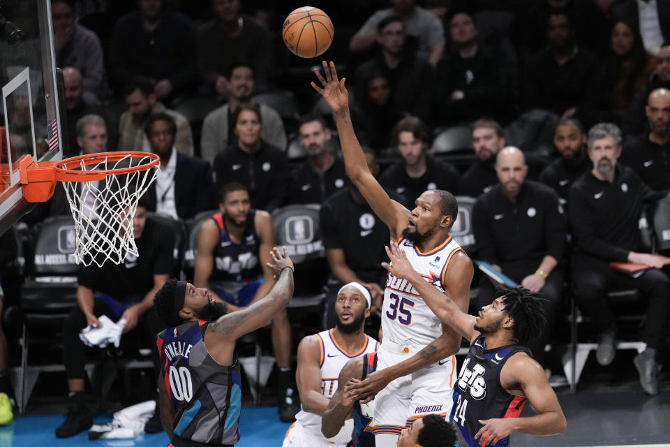 Phoenix Suns forward Kevin Durant (35) goes to the basket against Brooklyn Nets guard Cam Thomas (24) and forward Royce O'Neale (00) during the second half of an NBA basketball game, Wednesday, Jan. 31, 2024, in New York. The Suns won 136-120. (AP Photo/Mary Altaffer)