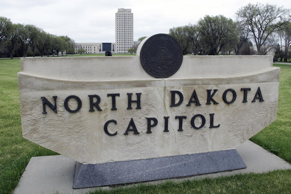 FILE - The North Dakota Capitol tower rises in the background behind a stone sign, April 19, 2012, in Bismarck, N.D. North Dakota’s Republican presidential caucuses are Monday, when voters will gather at 12 sites around the state. Donald Trump, Nikki Haley and two other candidates are on the ballot. (AP Photo/Dale Wetzel, File)