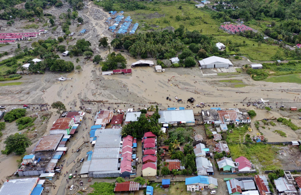 This aerial shot taken on Sunday, March 17, 2019 shows the area affected by flash floods in Sentani, Papua province, Indonesia. Flash floods and mudslides triggered by downpours tore through mountainside villages in Indonesia's easternmost province, killing dozens of people, disaster officials said. (AP Photo/Barce Rumkabu)