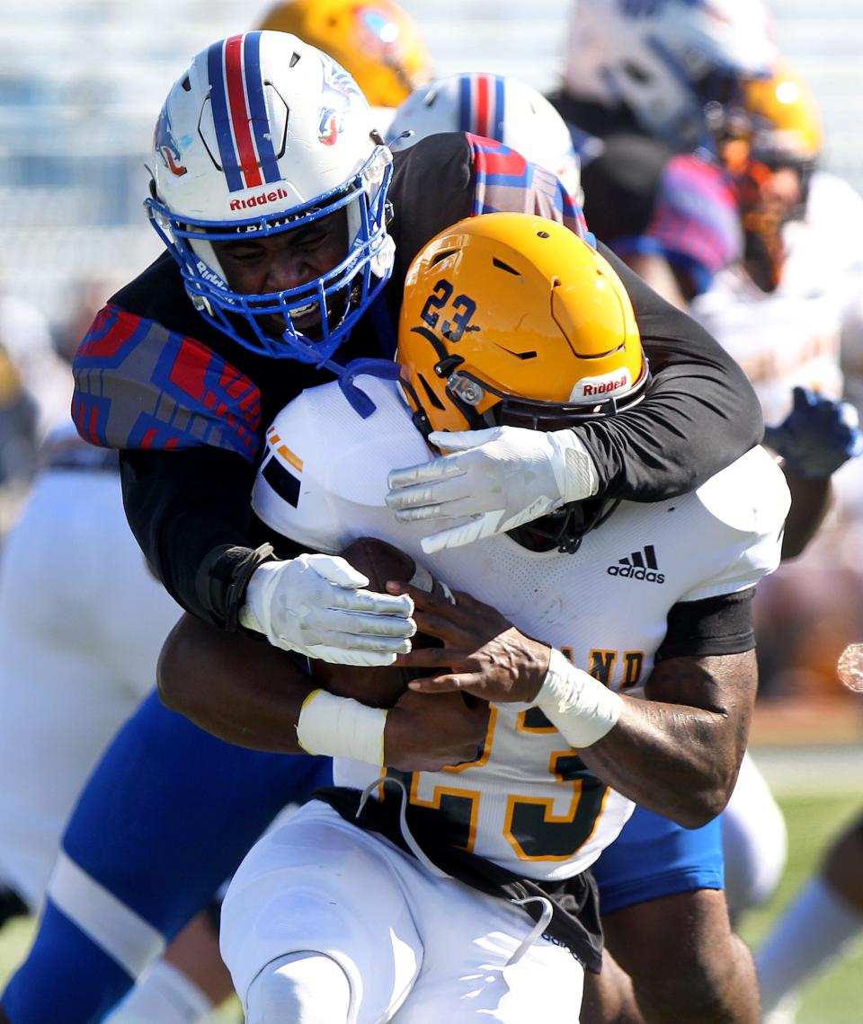 Highland's Brandon Robinson (23) is tackled by Hutchinson's Nadame Tucker (42) during their game Sunday, Nov. 7, 2021, at Gowans Stadium. Hutch CC defeated Highlands 77-0.