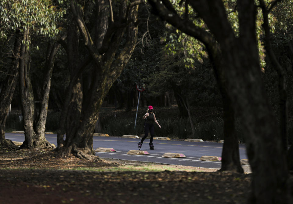 A woman wearing a protective face mask as a precaution against the spread of the new coronavirus skates at Chalputepec park in Mexico City, Sunday, April 26, 2020. (AP Photo/Fernando Llano)