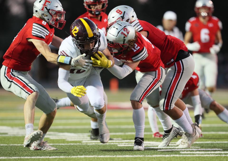 Edison of Stockton's Brennan Carr (12) tries to break away from Foothill's Hudson Edwards (8), Joel Christ (9), and Chris Hall (12) in the second quarter of their schools' game on Aug. 26, 2022. The Cougars won over Edison High School, 21-17, at home.