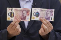 A person holds some of the newly released banknotes, featuring the portrait of King Charles III, outside the Bank of England, London, Wednesday June 5, 2024. (Lucy North/PA via AP)