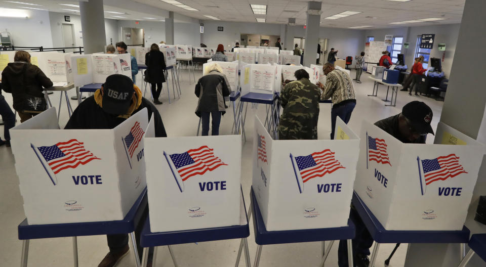 People participate in early voting, Friday, March 13, 2020, in Cleveland. (AP Photo/Tony Dejak)