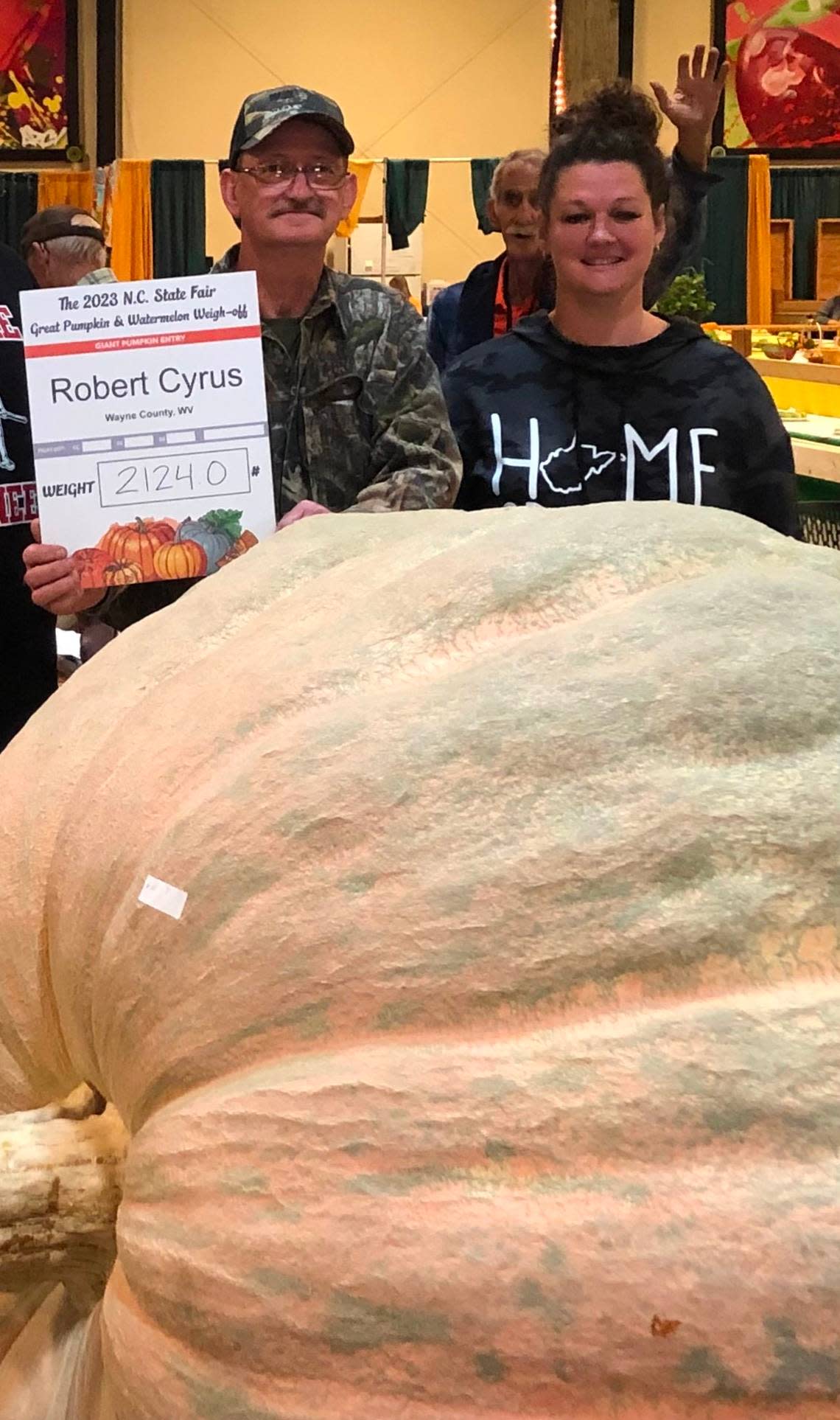 Robert Cyrus, center, with “Ruby,” his 2,124-pound pumpkin that took the top prize in this year’s giant produce competition at the N.C. State Fair on Tuesday. Cyrus lives in West Virginia and has been competing for eight years.