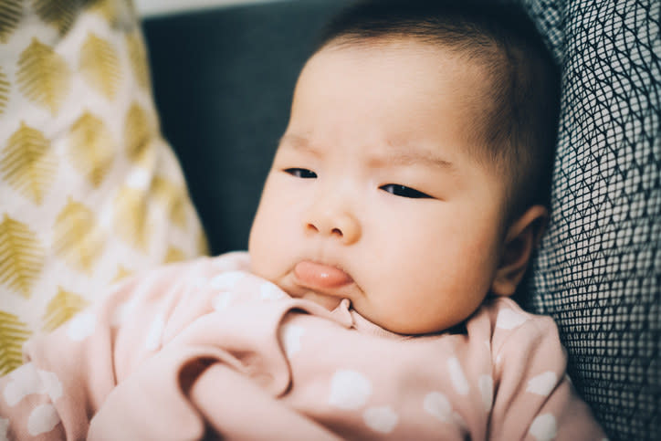 A baby jutting its lower lip out