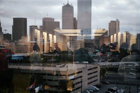 A reflection in a window shows police officers and media outside the court room on the first day of the trial against former Dallas police officer Amber Guyger, who is charged in the killing of Botham Jean in his own home, in Dallas