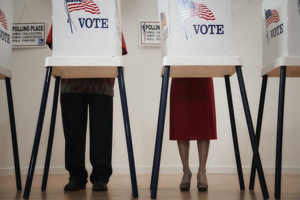 Two voting booths, with people in each one of them.