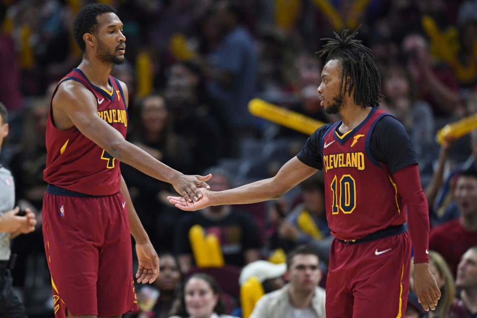 Cavaliers forward Evan Mobley, left, and guard Darius Garland slap hands against the Milwaukee Bucks on April 10, 2022, in Cleveland.