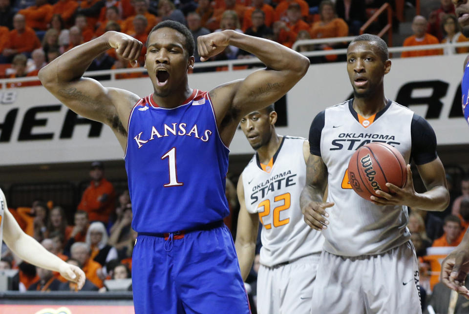 Kansas guard Wayne Selden Jr. (1) reacts to a basket in front of Oklahoma State wing Markel Brown (22) and post Kamari Murphy in the first half of an NCAA college basketball game in Stillwater, Okla., Saturday, March 1, 2014. (AP Photo/Sue Ogrocki)