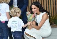 Strike a posie: Meghan has been presented with gifts at every turn from people young and old