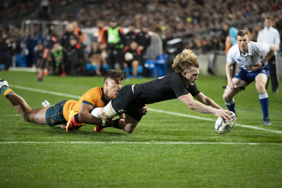 New Zealand's Damian McKenzie, right, scores a try against Australia during their Bledisloe Cup rugby union test match at Eden Park in Auckland, New Zealand, Saturday, Aug. 7, 2021. (Brett Phibbs/Photosport via AP)