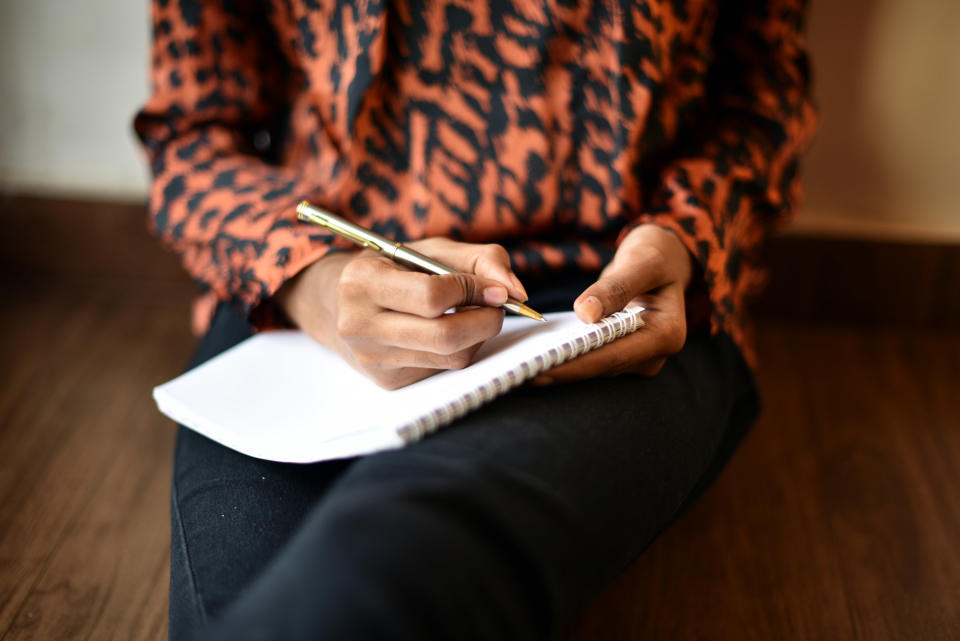 A person with a pen and notebook