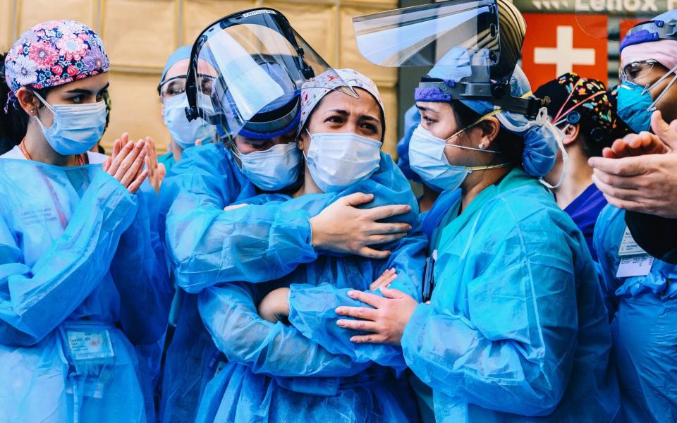 Medical workers are seen outside Lenox Health Greenwich Village as people applaud at 7pm to show their gratitude to medical staff and essential workers on the front lines of the coronavirus pandemic - Nina Westervelt/Shutterstock 