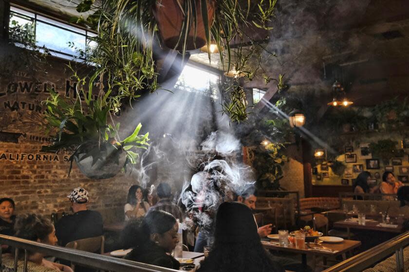 FILE - Patrons smoke marijuana at Lowell's Original Cannabis Cafe, a legal marijuana establishment, in Los Angeles, Nov. 13, 2019. Marijuana advocates are gearing up for Saturday, April 20, 2024. Known as 4/20, marijuana's high holiday is marked by large crowds gathering in parks, at festivals and on college campuses to smoke together. (AP Photo/Richard Vogel, File)