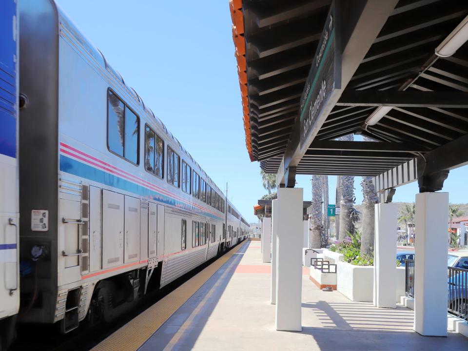 An Amtrak Pacific Surfliner train passing through San Clemente train station in California.