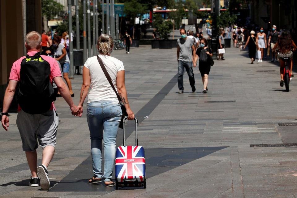 People wear protective face masks as they arrive in Barcelona (REUTERS)