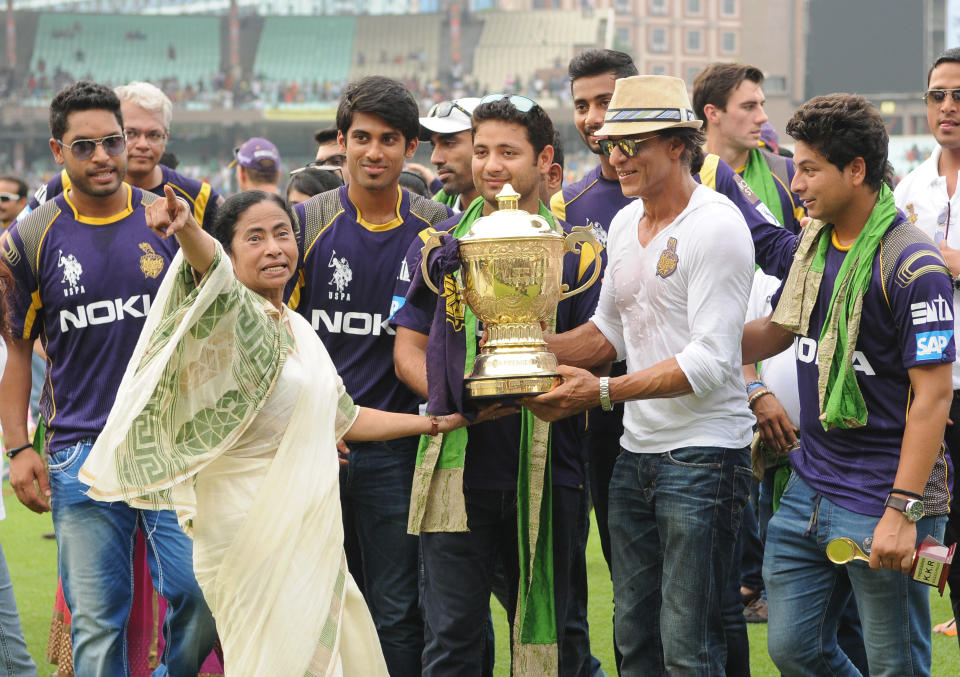 KOLKATA, INDIA - JUNE 3: West Bengal Chief Minister Mamata Banerjee with Kolkata Knight Riders owner Shah Rukh Khan and players holding the champions trophy during felicitation ceremony of the IPL champions Kolkata Knight Riders on June 3, 2014 in Kolkata, India. (Photo by Ashok Nath Dey/Hindustan Times via Getty Images)