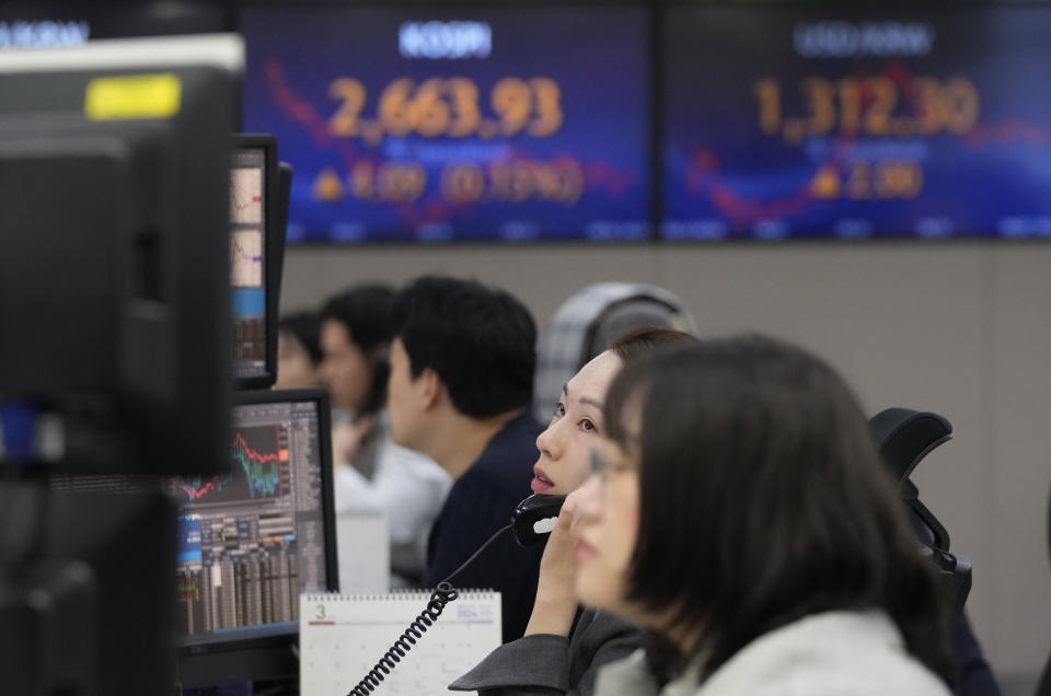 A currency trader talks on the phone at the foreign exchange dealing room of the KEB Hana Bank headquarters in Seoul, South Korea, Tuesday, March 12, 2024. Shares were mostly higher in Asia on Tuesday ahead of a report on inflation in the U.S. that could sway the Federal Reserve’s timing on cutting interest rates. (AP Photo/Ahn Young-joon)