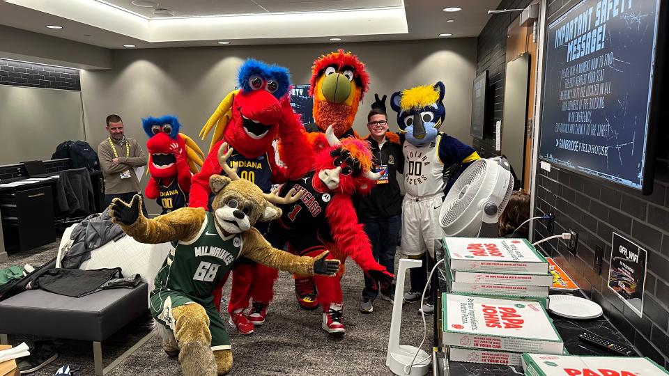 Owen Carr is flanked by NBA mascots at Boomer's birthday party.
