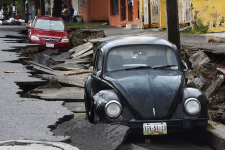 Cars are seen on a street damaged due to heavy rains in Veracruz September 2, 2014. REUTERS/Jonatan Rosas