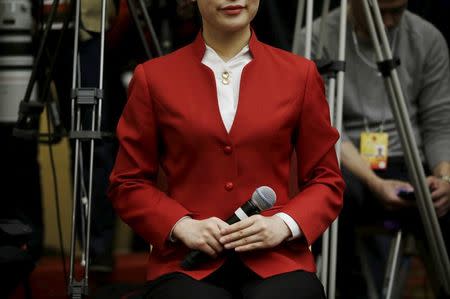 An attendant holding a microphone serves at a news conference by China's Environmental Protection Minister Chen Jining on the sidelines of the National People's Congress (NPC) in Beijing, China, March 11, 2016. REUTERS/Jason Lee