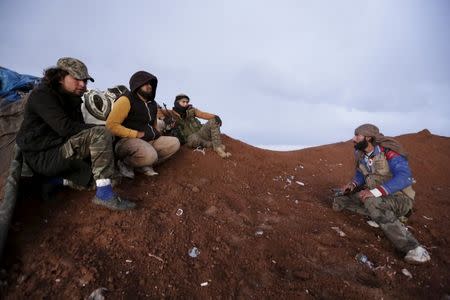 Rebel fighters of the Al-Furqan brigade sit on a look-out point with their weapons in Aziziyah village, southern Aleppo countryside, Syria March 5, 2016. REUTERS/Khalil Ashawi