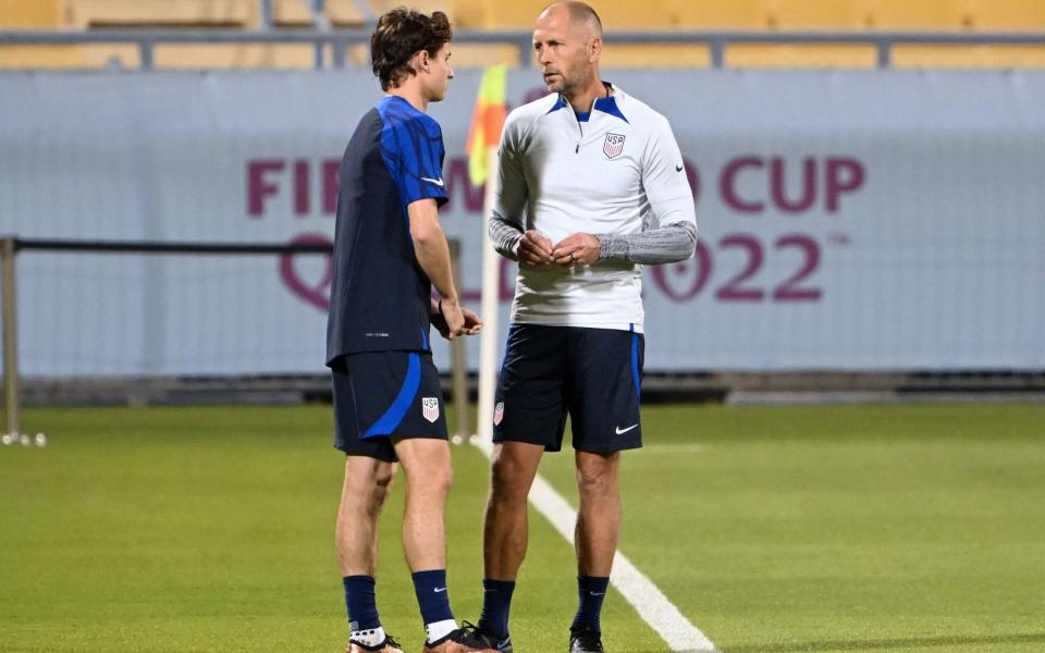 USA's coach Gregg Berhalter (R) speaks with USA's midfielder #11 Brenden Aaronson - AFP/PATRICK T. FALLON