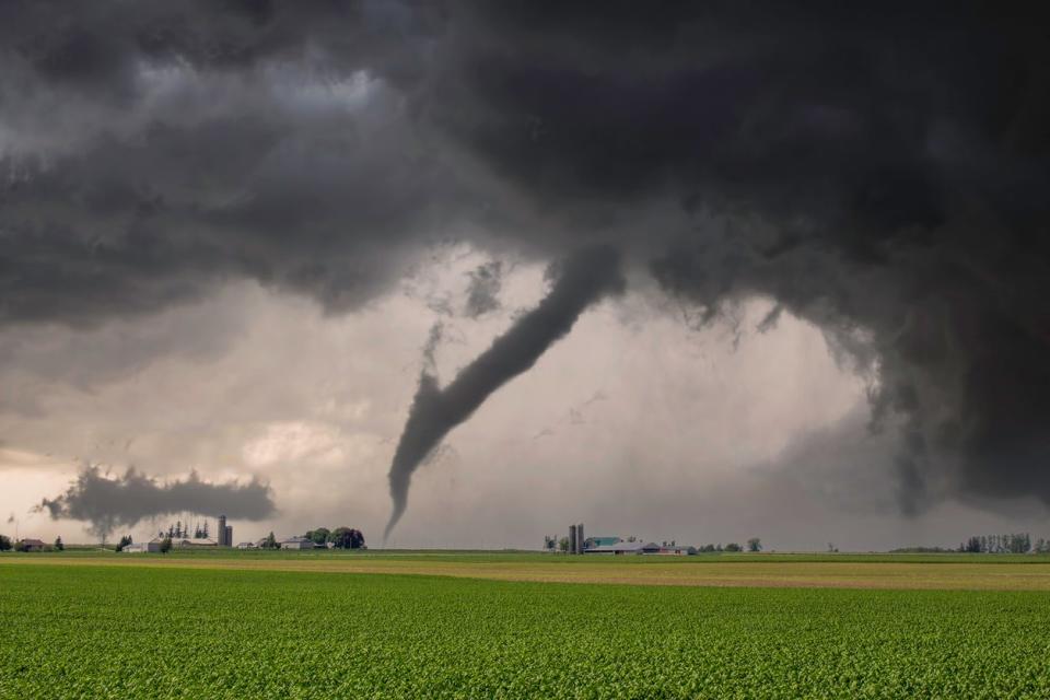 Tornado touching down over an open field.