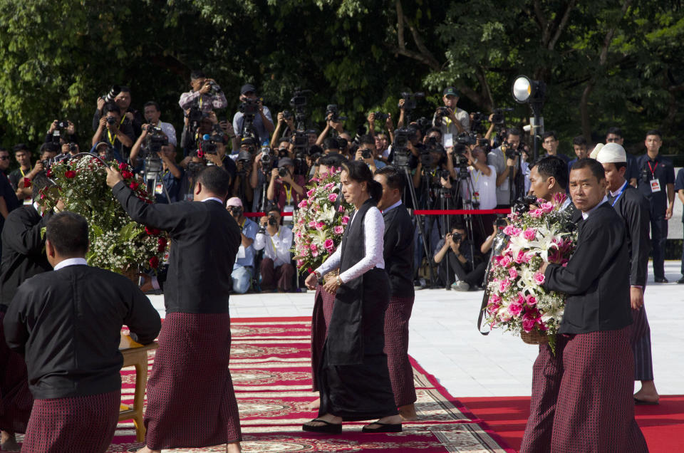 Myanmar leader Aung San Suu Kyi, center, walks to offer flower basket at the tomb of her late father and Myanmar's independence hero Gen. Aung San during a ceremony to mark the 72nd anniversary of his 1947 assassination, at the Martyrs' Mausoleum Friday, July 19, 2019, in Yangon, Myanmar. The country's Independence hero Gen. Aung San and his cabinet were gunned down in 1947. (AP Photo/Thein Zaw)