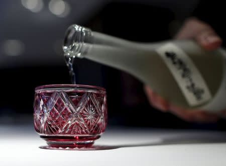 A staff of Tokyo's French restaurant Narisawa pours a junmai daiginjo sake into a Japanese traditional Edo Kiriko glass, a faceted glass from the Edo period, to pair with a dish called "Five flavors", for an early spring menu which includes Akaza Ebi, or langoustine shrimp, from Suruga Bay in central Japan, accented with "green caviar" of various green peas, along with the petals of rucola flowers and viola, at Narisawa in Tokyo March 26, 2015. REUTERS/Yuya Shinoâ€¨