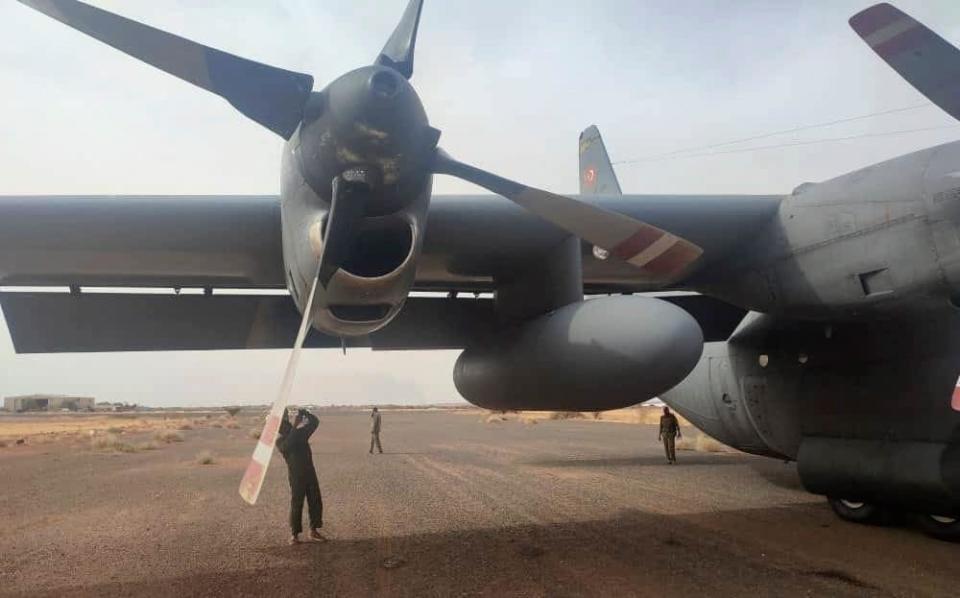 Workers inspect the plane after it lands at Wadi Seidna airfield near Khartoum - AFP