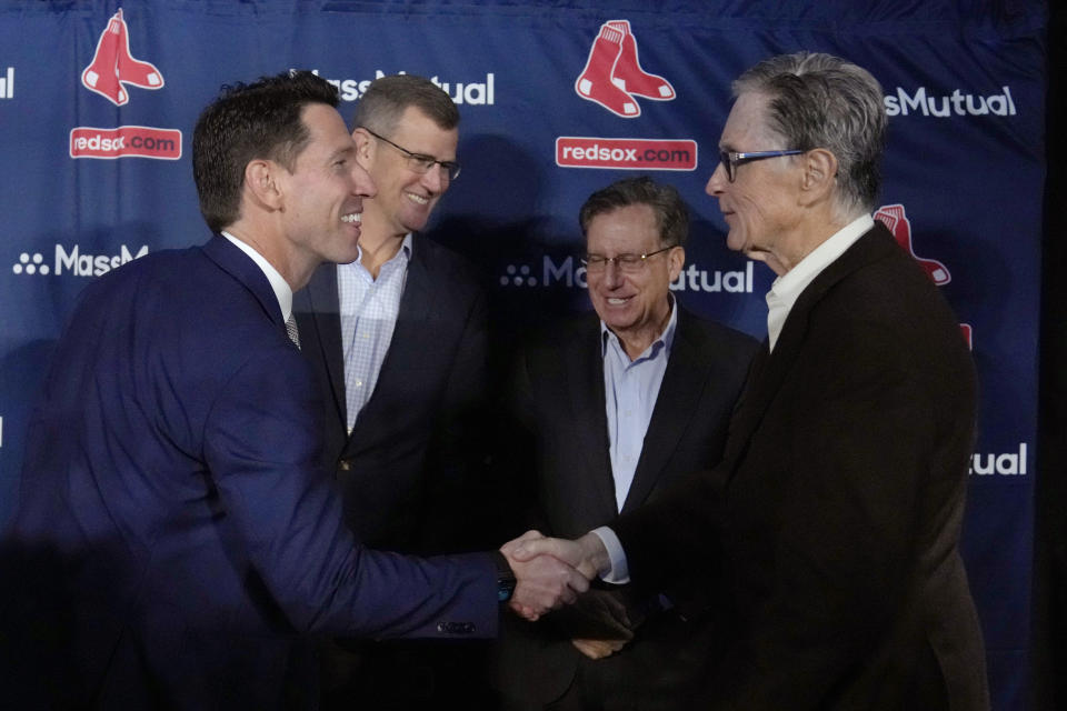 Craig Breslow, left, Boston Red Sox chief baseball officer, shakes hands with team owner John Henry after a news conference at Fenway Park, Thursday, Nov. 2, 2023, in Boston. At rear left is team president Sam Kennedy, and at rear right is team chairman Tom Werner. (AP Photo/Charles Krupa)