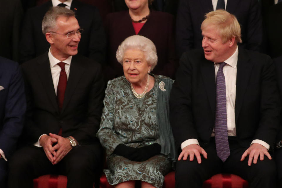 NATO Secretary General Jens Stoltenberg, Britain's Queen Elizabeth II and Britain's Prime Minister Boris Johnson sit together at Buckingham Palace in central London on December 3, 2019, as leaders of Nato alliance countries, and its secretary general, join Queen Elizabeth II and the Prince of Wales for a group picture to mark 70 years of the alliance ahead of the NATO alliance summit. - NATO leaders gather Tuesday for a summit to mark the alliance's 70th anniversary but with leaders feuding and name-calling over money and strategy, the mood is far from festive. (Photo by Yui Mok / POOL / AFP) (Photo by YUI MOK/POOL/AFP via Getty Images)