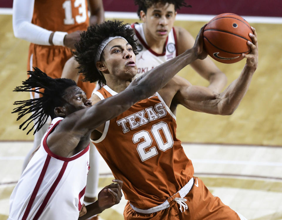 Texas forward Jericho Sims (20) grabs a rebound over Oklahoma Victor Iwuakor (0) during the first half of an NCAA college basketball game in Norman, Okla., Thursday, March 4, 2021. (AP Photo/Kyle Phillips)