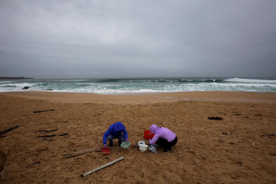 Women clean up the sand of Vilar beach after millions of plastic pellets washed up on the Spanish northwestern Galicia region. / Credit: MIGUEL VIDAL / REUTERS