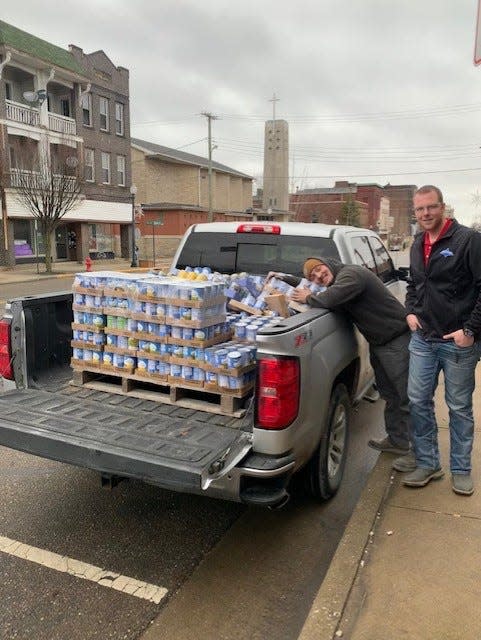 Trailstar employees Joe Coffman, left, and Mason Hahn load up a pickup with the Smith Township company's donation of food to Clothed in Righteousness, a charity that works with the homeless and needy in the Alliance area.